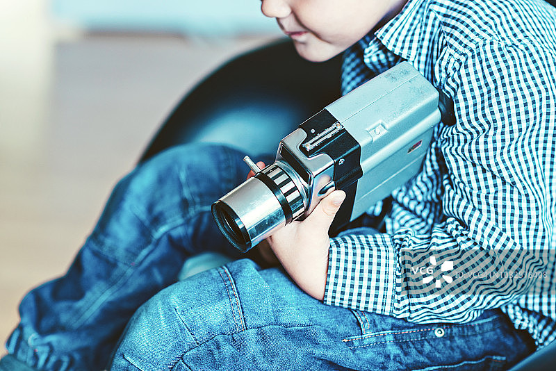 一个男孩手中的老式复古摄像机的特写图片素材