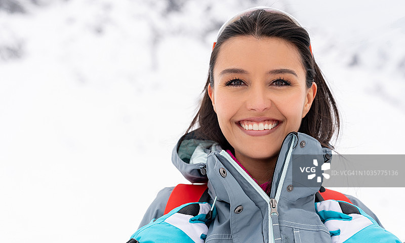 一个快乐的女人在雪山徒步旅行的肖像图片素材