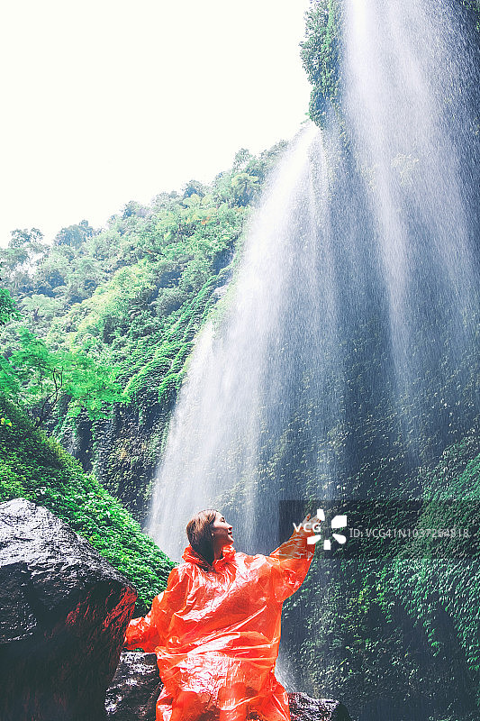 旅行女人冒险和站在Madakaripura瀑布放松，东爪哇岛，印度尼西亚图片素材