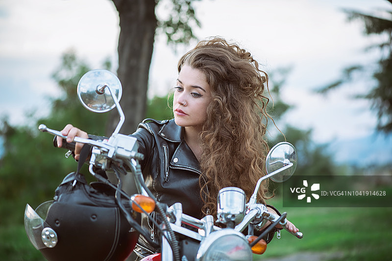 骑摩托车的头发凌乱的女人图片素材