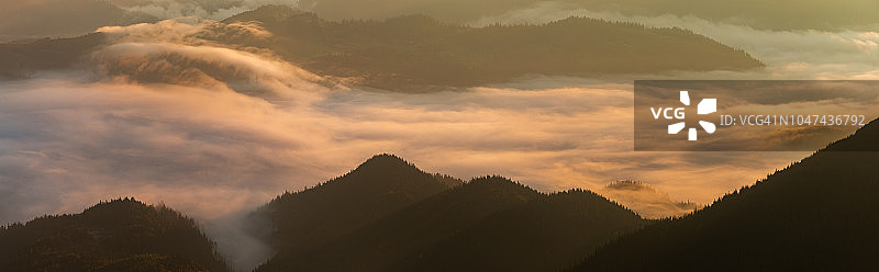 群山中雾蒙蒙的黎明全景。美丽的景观图片素材