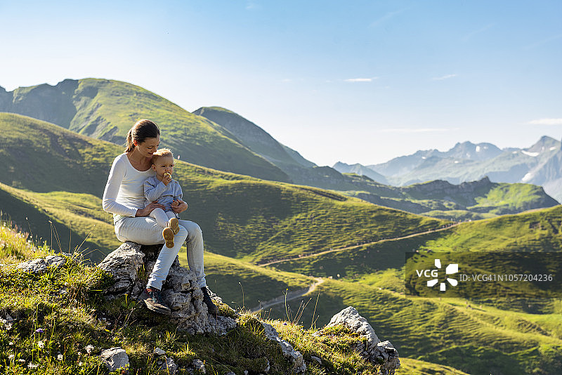 德国，巴伐利亚，奥伯斯特多夫，母亲和小女儿在山里徒步休息图片素材