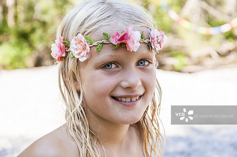 在夏天戴着花冠的微笑女孩的肖像图片素材