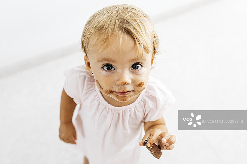 小女孩吃巧克力饼干的肖像图片素材