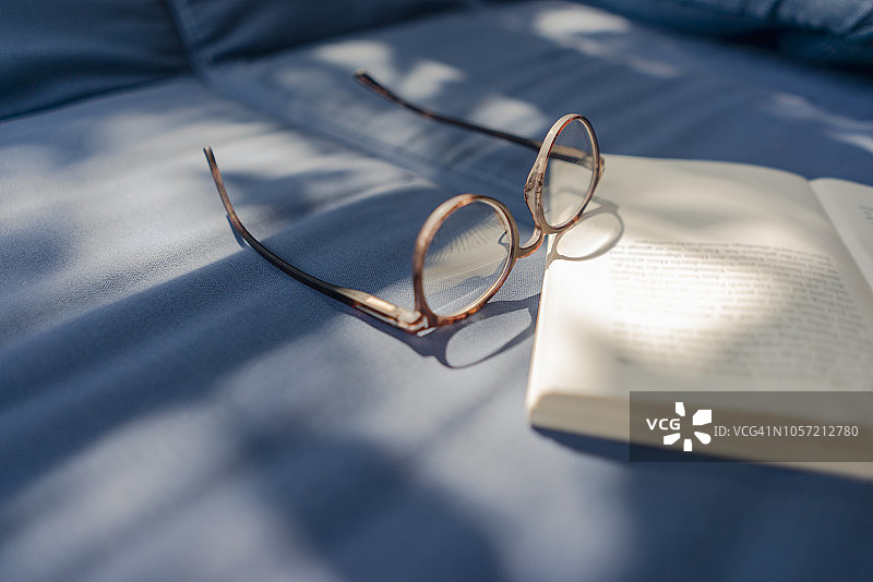 眼镜和书躺在沙发上图片素材