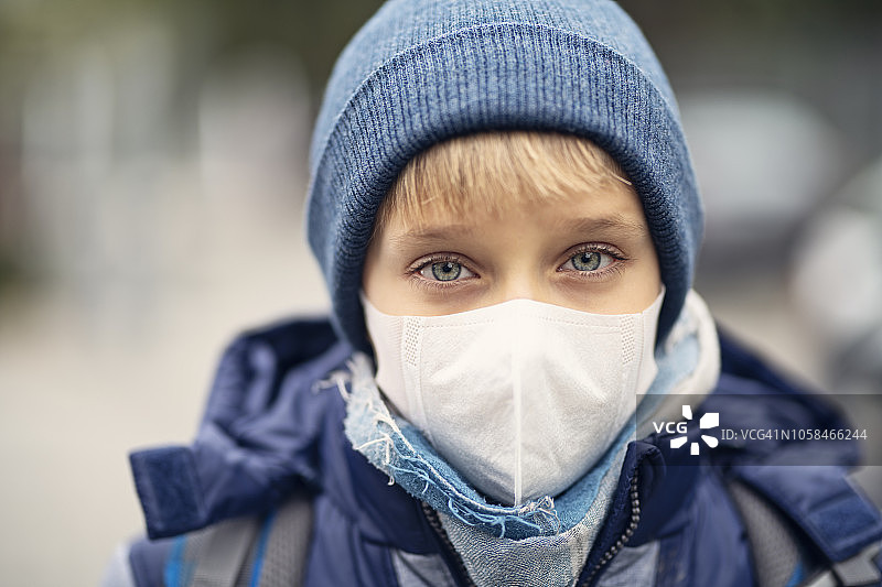 小男孩戴着污染口罩去上学图片素材