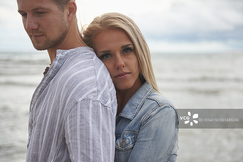 一对年轻情侣在海滩上拥抱图片素材