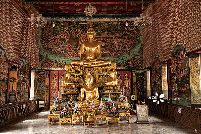 在曼谷的佛寺里，室内闪闪发光的金色佛像图片素材