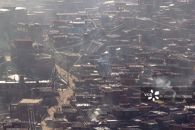 在一个温暖而有雾的早晨，俯瞰拉隆噶佛教学院的寺院图片素材