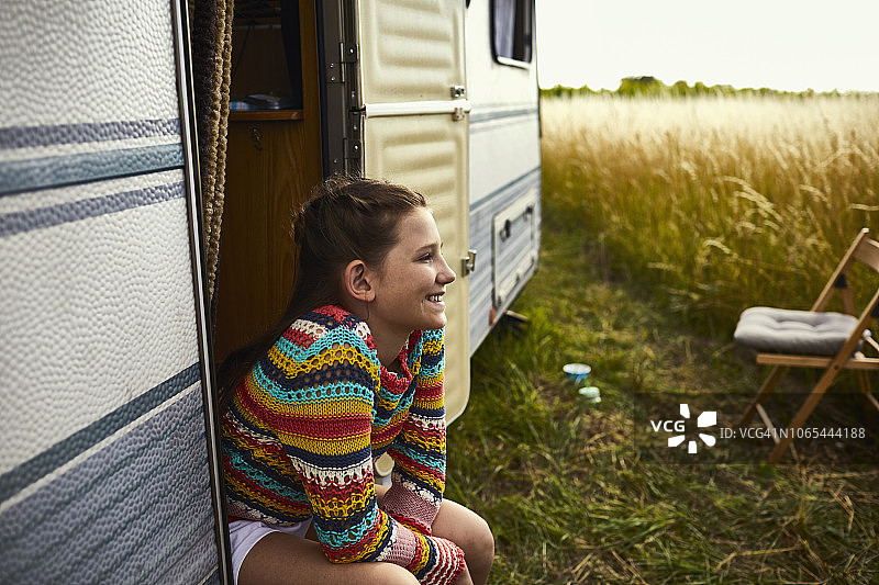 微笑的女孩坐在大篷车的门口图片素材