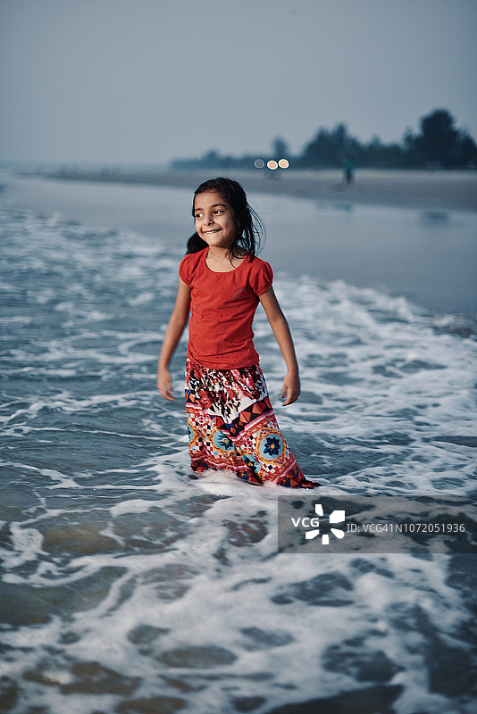 年轻的女孩(4-5岁)在海滩上玩图片素材