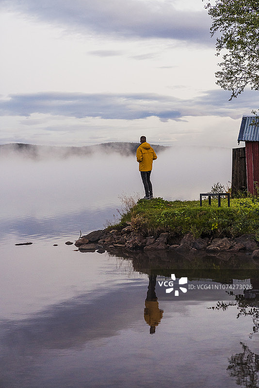 孤单一人站在湖边，望着雾图片素材