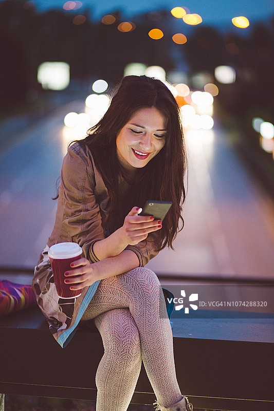 一个晚上在城里喝咖啡发短信的女人图片素材