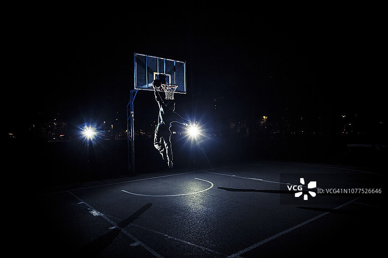 年轻人在晚上打篮球图片素材