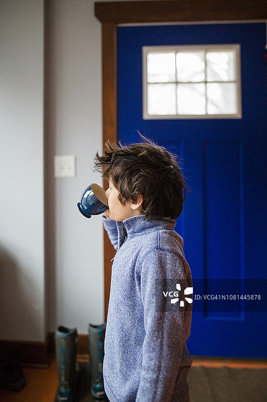站在家里喝咖啡的男孩的侧视图图片素材