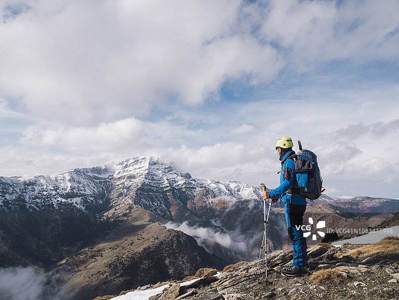 年长的高山攀登者在冬季观看山顶的美景图片素材
