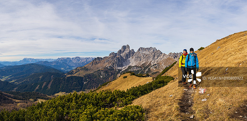 全景徒步旅行夫妇在温暖的户外运动服一起走在小路上高在奥地利山脉图片素材