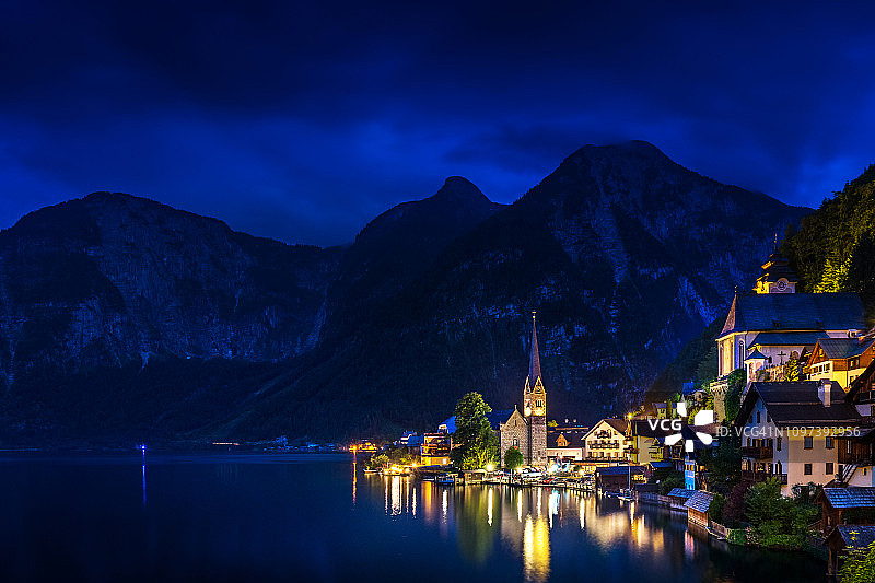 哈尔斯塔特村，日落后，哈尔斯塔特湖上的教堂和高阿尔卑斯山山的背景图片素材