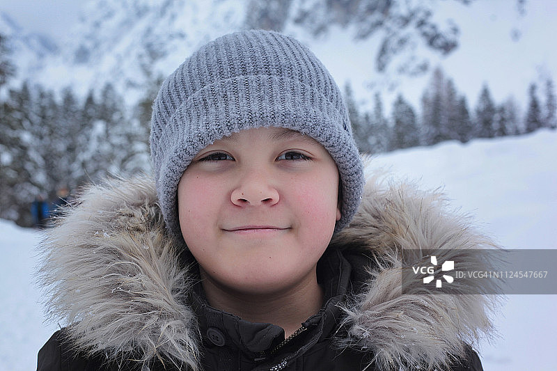 一个男孩在冬天徒步旅行的肖像。图片素材