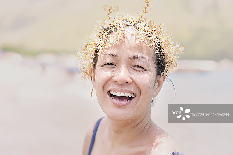 在海滩上戴着海草冠的女人图片素材