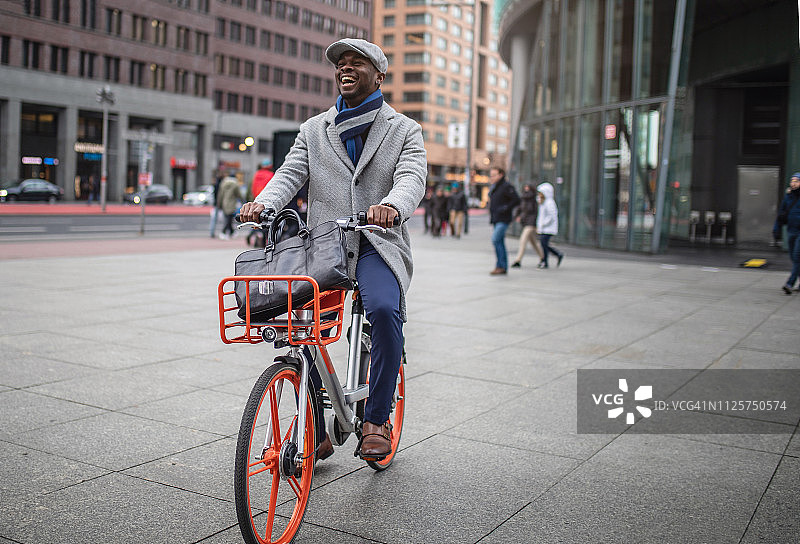 快乐的商人骑着自行车去上班图片素材