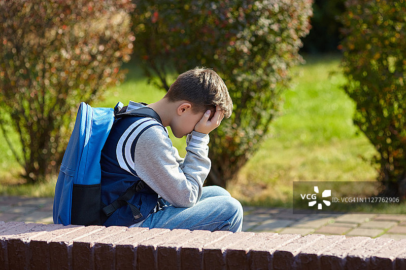 一个男生在学校的院子里哭图片素材