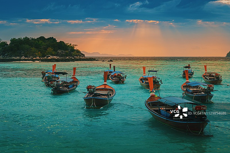 美丽的泰国传统长尾船在日落时分停泊在海里图片素材