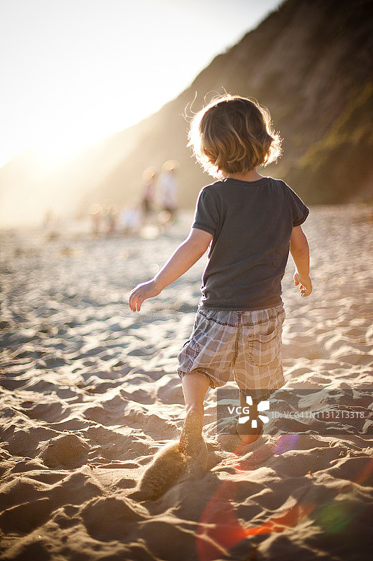 日落时分沙滩上的小男孩图片素材
