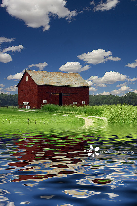 红谷仓在麦田，河流或湖岸图片素材