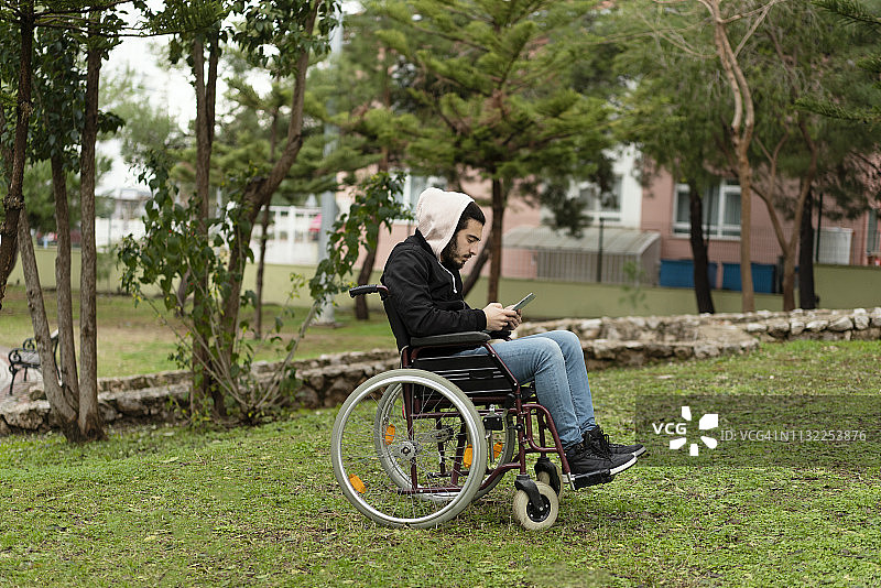 残疾人在公园里使用平板电脑图片素材