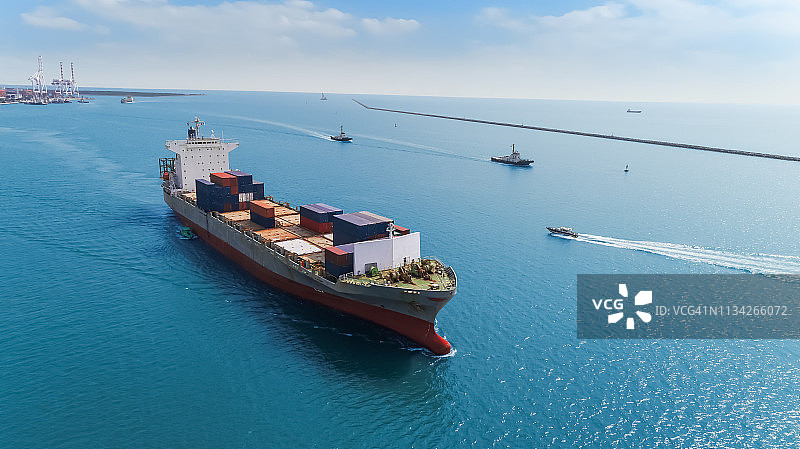 鸟瞰图集装箱船在海港与蓝天交付集装箱物流业务，进出口，航运或运输。图片素材