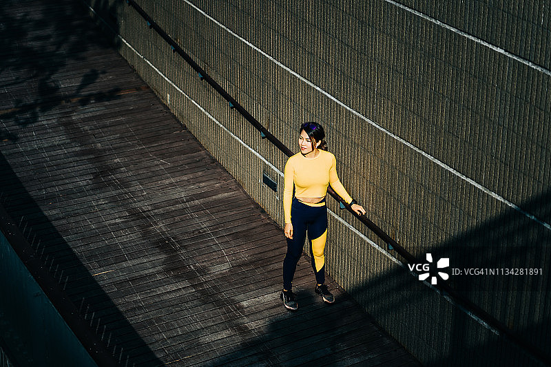 年轻的女运动员在城市的城市公园慢跑后休息图片素材