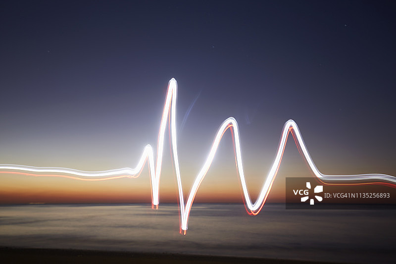 光迹就像日落时海滩上的心电图(光画、脉搏迹、心率线)图片素材