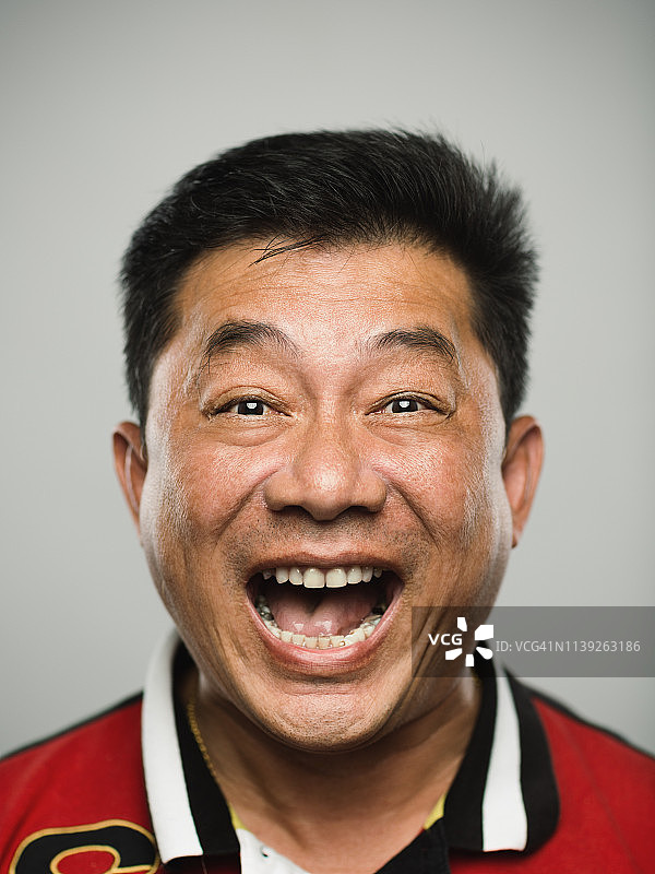 真正的中国成熟男人的肖像，带着狂喜的表情看着相机图片素材