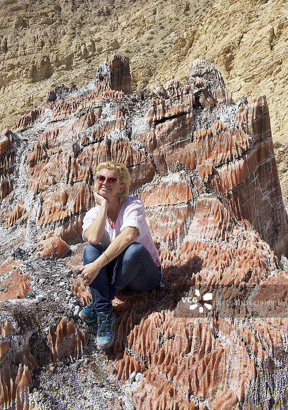 坐在岩石上微笑的女人，盐山，伊朗图片素材