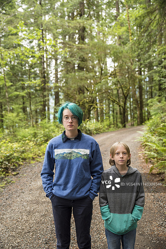 兄弟姐妹站在奥林匹克国家公园树木中间的道路上的肖像图片素材