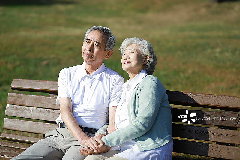 老夫妇坐在公园长椅上图片素材