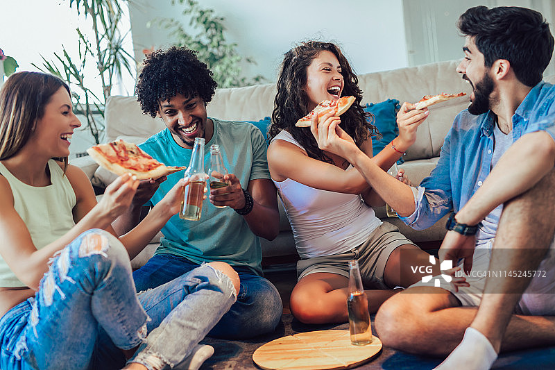 一群年轻人在吃披萨。家庭聚会。快餐的概念。图片素材