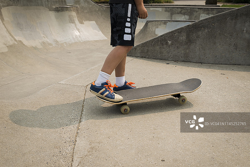 在公园运动坡道上的男孩滑板的低部分图片素材