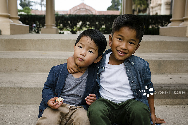 可爱的男孩和哥哥坐在巴尔博亚公园的台阶上的肖像图片素材