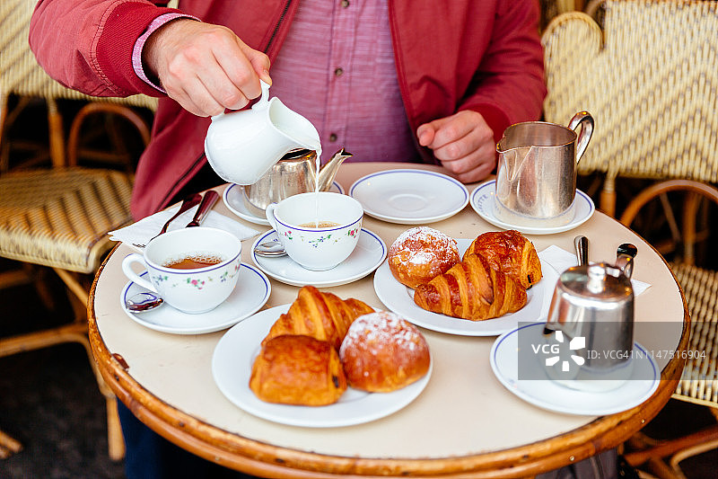 在法国巴黎街头的路边咖啡馆里吃法式早餐图片素材
