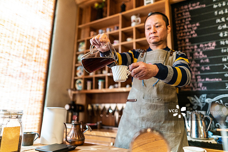 中国自助餐厅的工作人员正在往杯子里倒咖啡图片素材