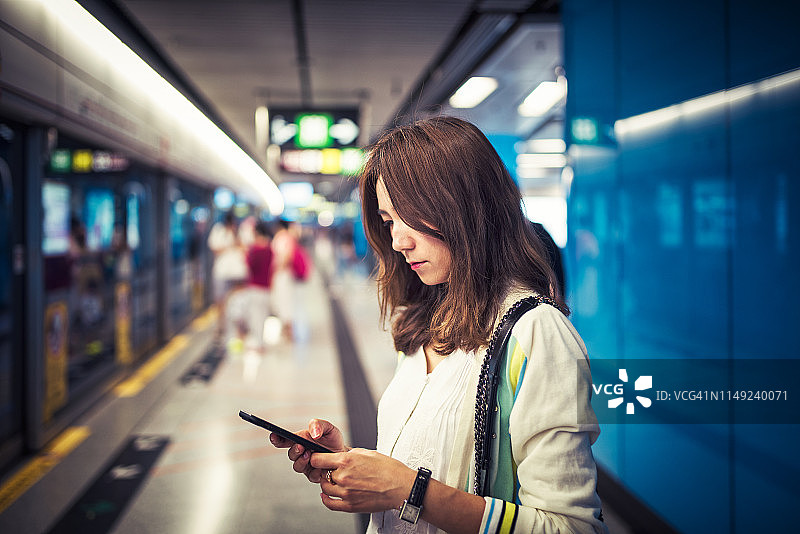 亚洲女性在地铁站使用手机图片素材
