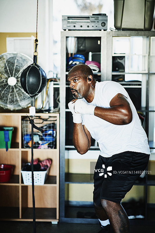 男拳击手在拳击馆里用双端包健身图片素材
