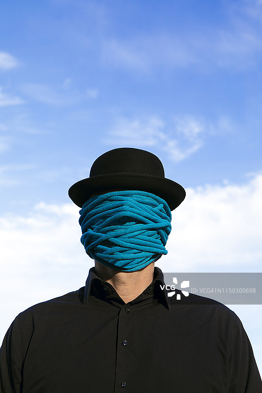 一名男子戴着圆顶礼帽，脸上缠着绳子图片素材