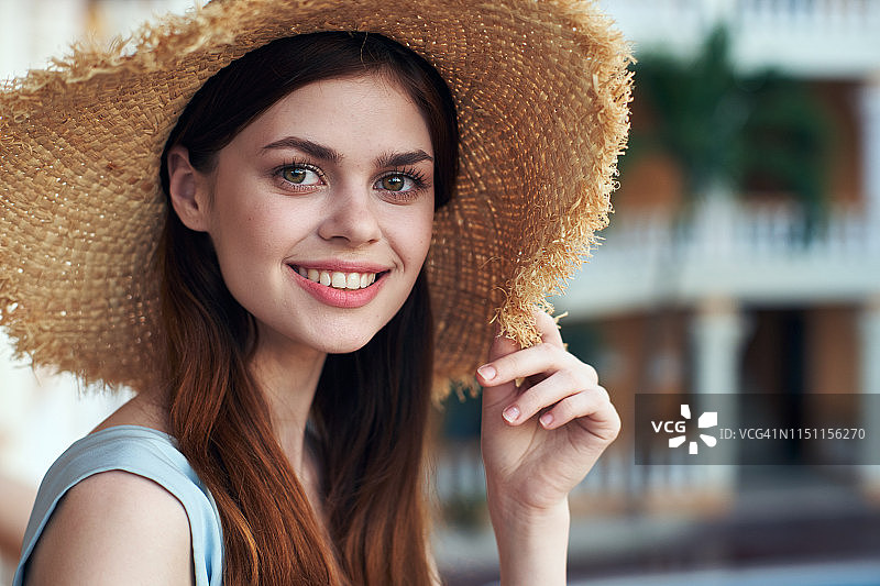 一个女人的肖像与美丽的微笑在一个夏天的草帽图片素材