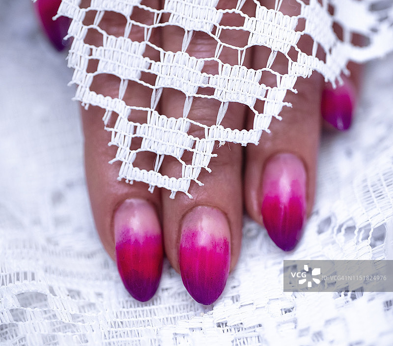 特写的女人的手指与指甲艺术美甲与霓虹灯粉红色图片素材