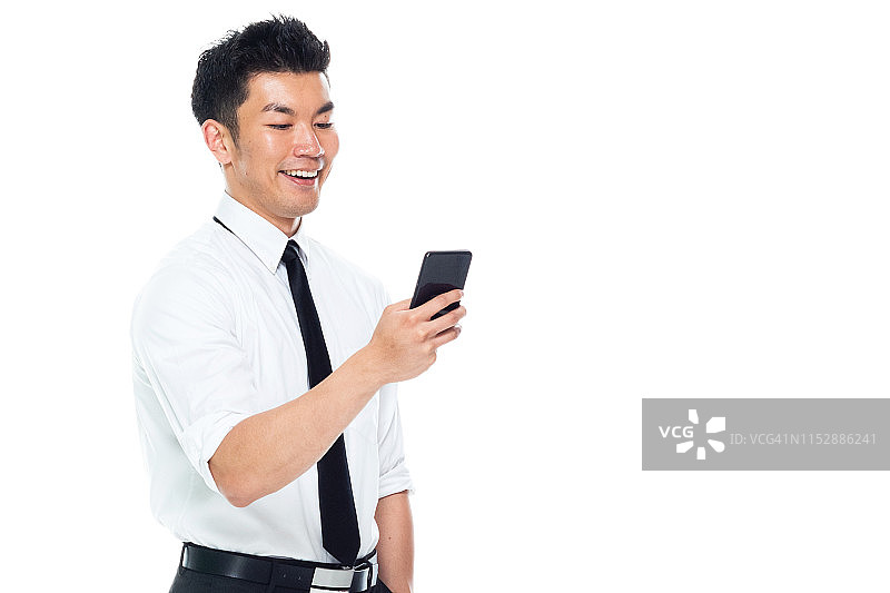 英俊的亚洲商人-短信智能手机图片素材