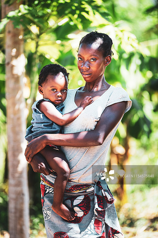 一个年轻的非洲妇女和她的孩子坐在一起的肖像图片素材