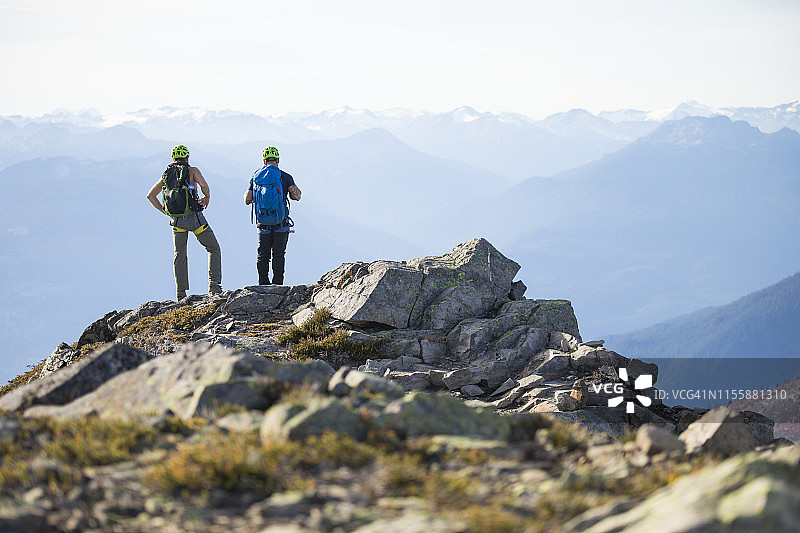 两名登山者站在不列颠哥伦比亚省的道格拉斯峰的顶峰。图片素材